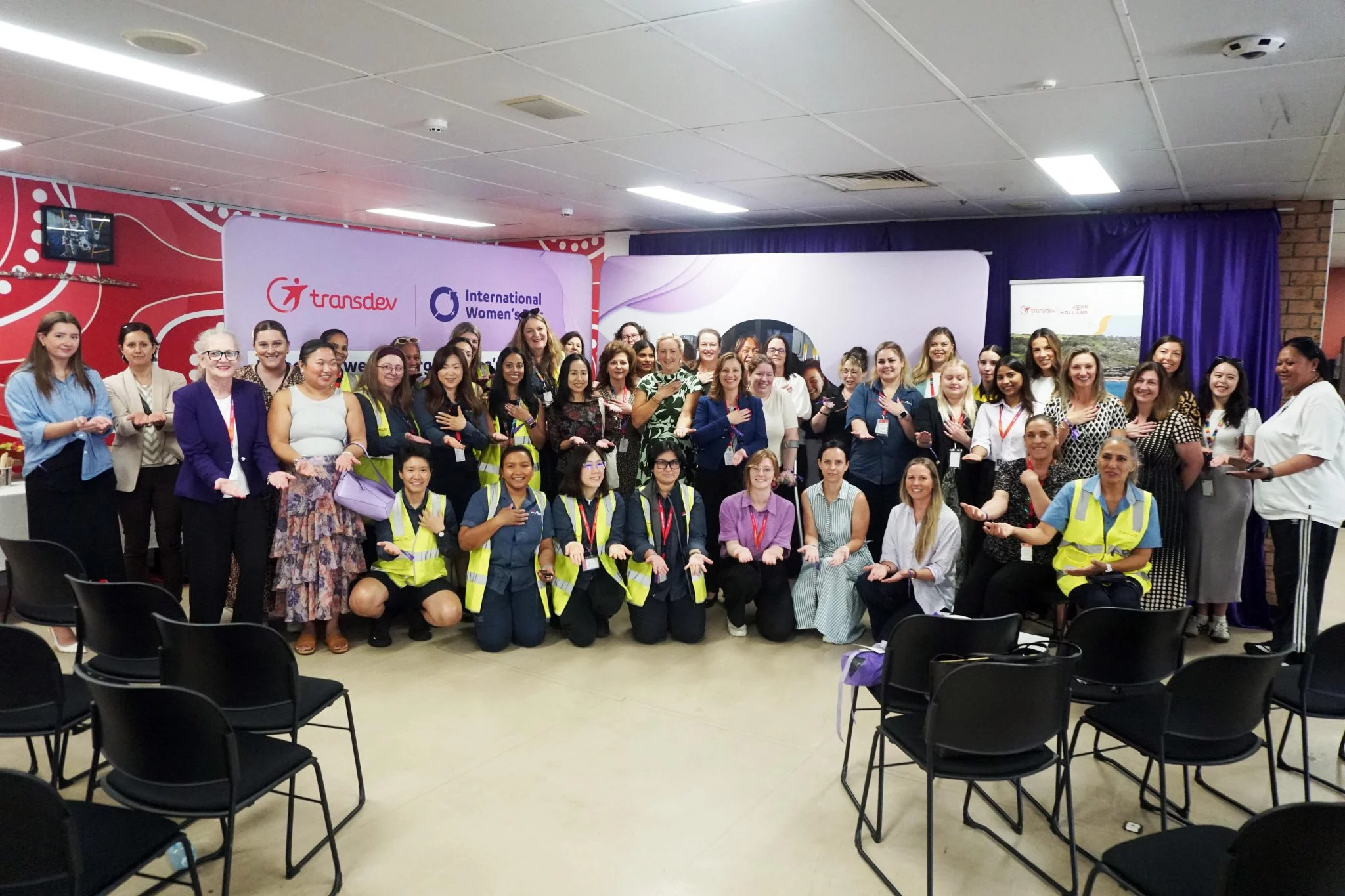 Large group on women, all in different uniforms smiling at the camera.