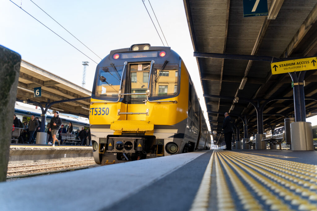 An image of a yellow train sitting at a train platform.